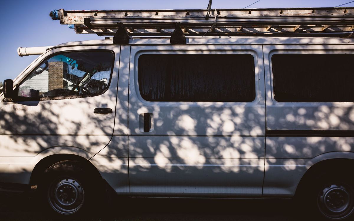 One of the shop's white work vans with a ladder rack